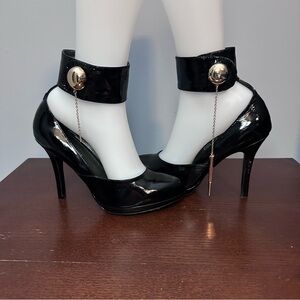black patent leather high-heeled pumps with ankle cuff and gold hardware